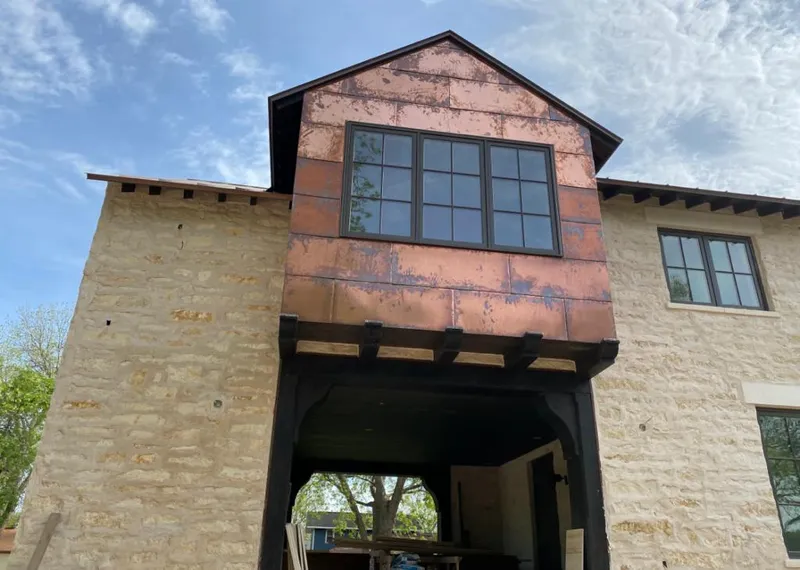 Copper metal panel facade on a stone building for Roof Repair in Coolidge