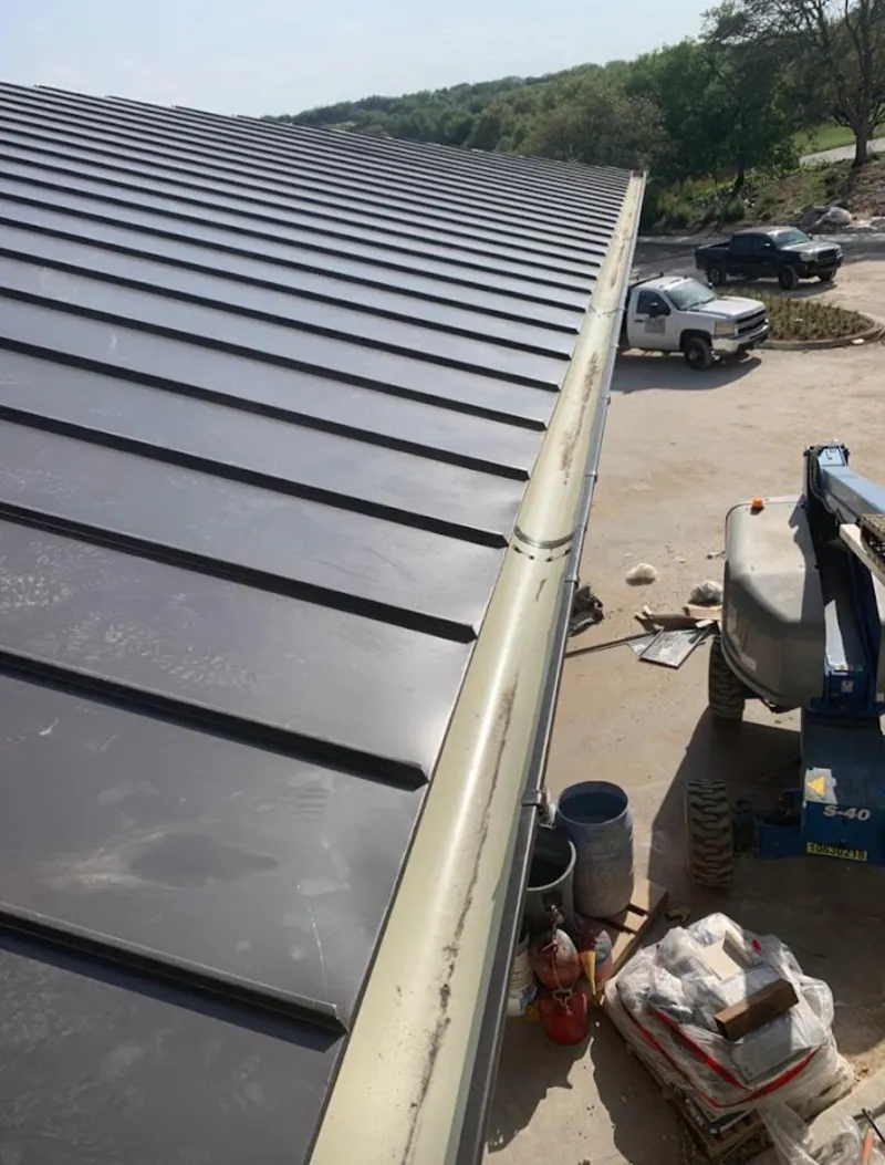 Standing seam panel and gutter detail on a metal roofing jobsite in Coolidge